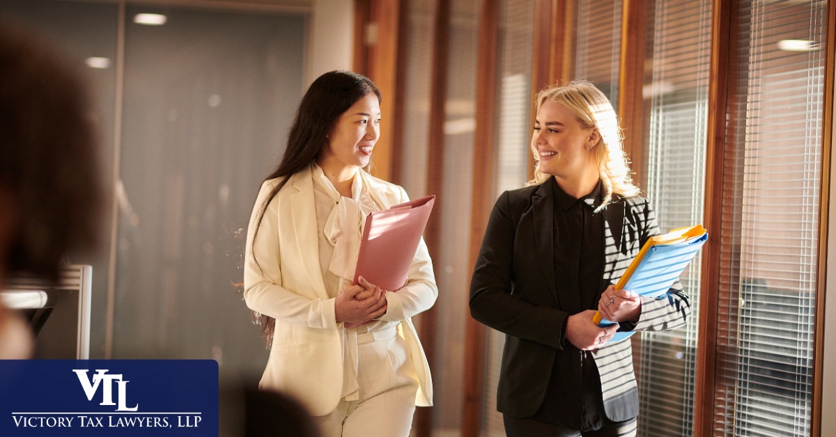 Two tax professionals discussing a client file in an office