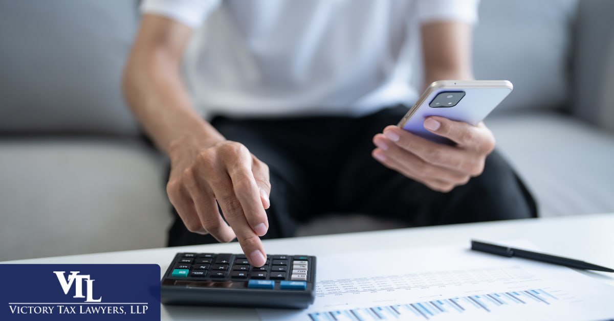 Taxpayer using a calculator and phone to plan an IRS settlement