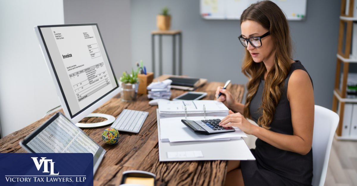 Tax professional reviewing a client's financial documents at a desk