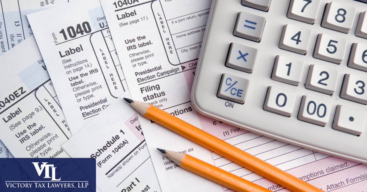 IRS 1040 tax forms and a calculator used when filing an Offer in Compromise