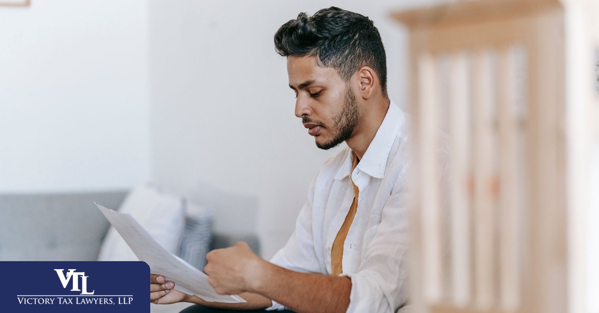 Taxpayer reading an IRS CP14 balance due notice at his desk
