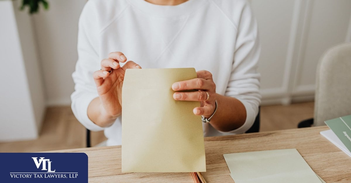 Taxpayer opening a Franchise Tax Board collection notice at a desk